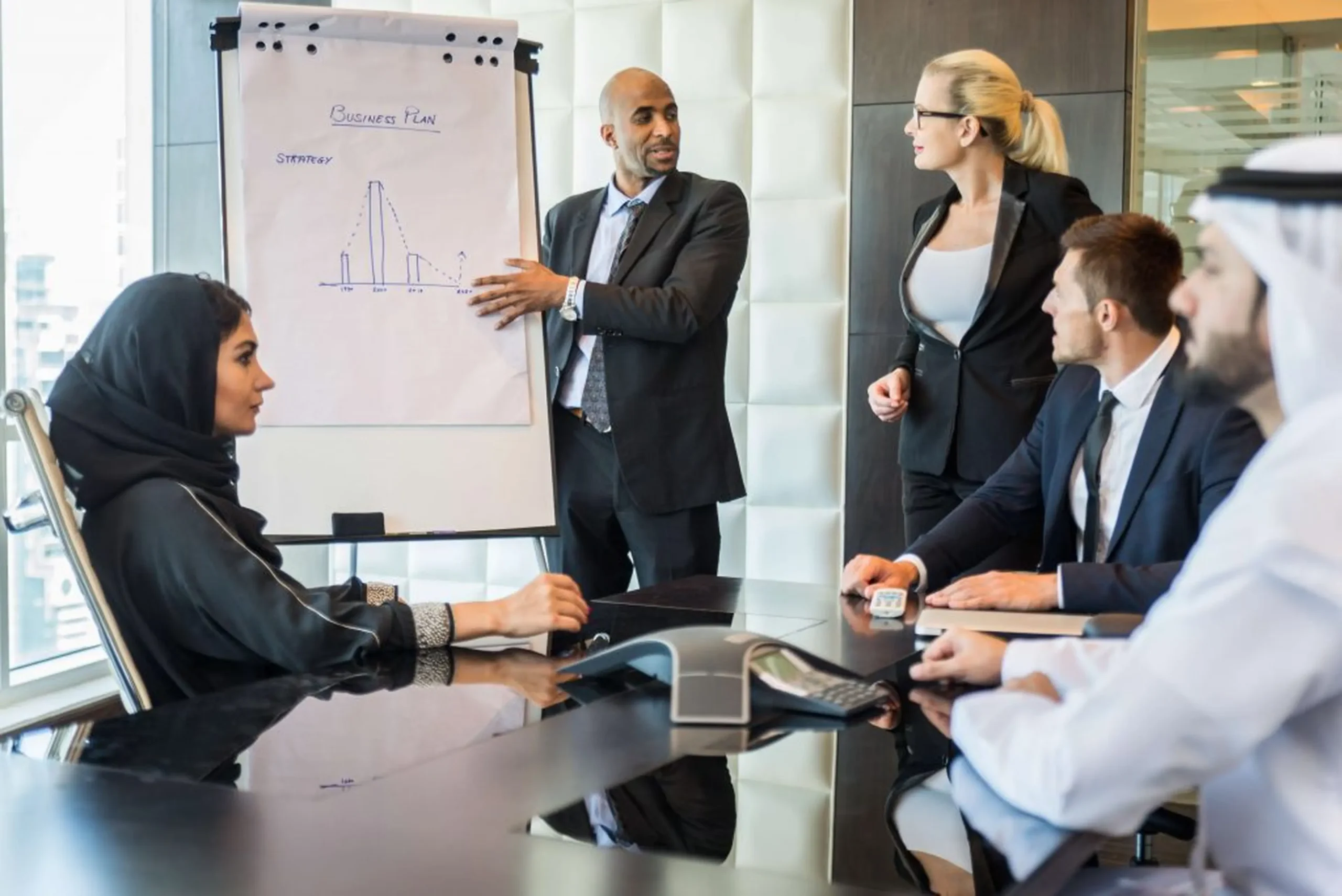 Diverse business team discussing a strategy presentation in a boardroom, more reasons why learn Arabic can help with your career.