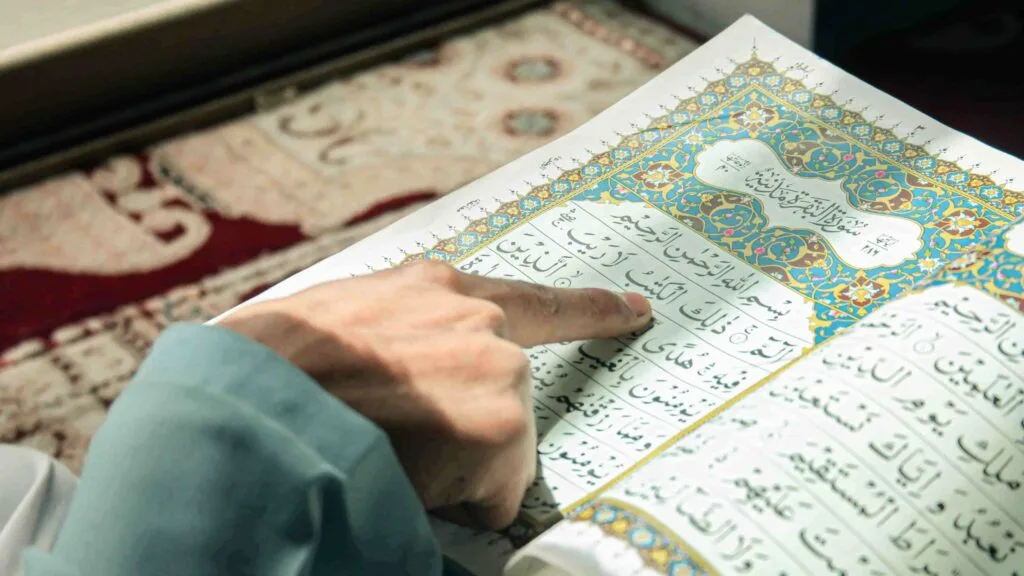 Finger tracing Arabic script while reading the Quran, focused on reading comprehension