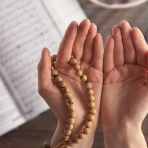 Open hands raised in dua with prayer beads, symbolizing daily duas every Muslim should memorize