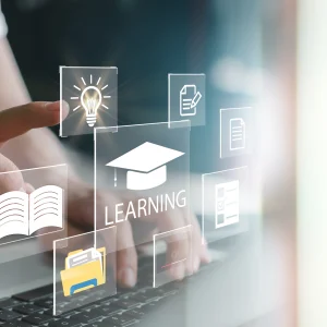Hand touching a laptop with digital icons representing online learning, including a book, graduation cap, and document icons