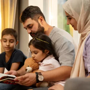 Muslim father reading with his children at home, illustrating the best age to start teaching Arabic for kids